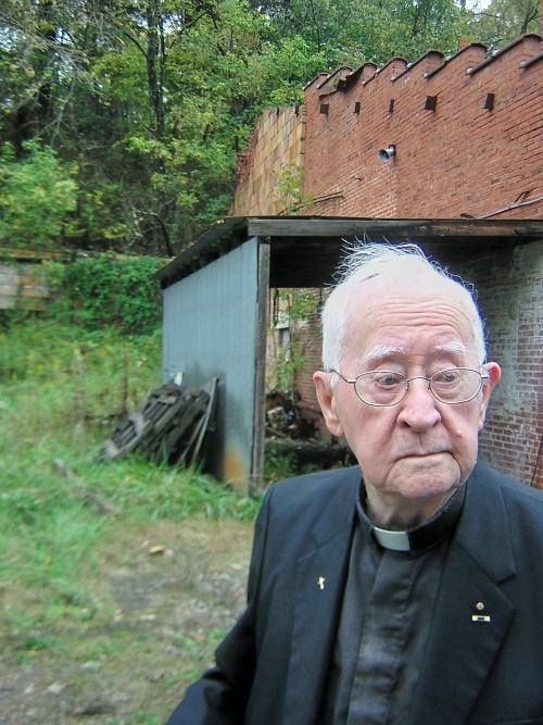 Padre Everett Briggs davanti all'ingresso ormai chiuso della vecchia miniera